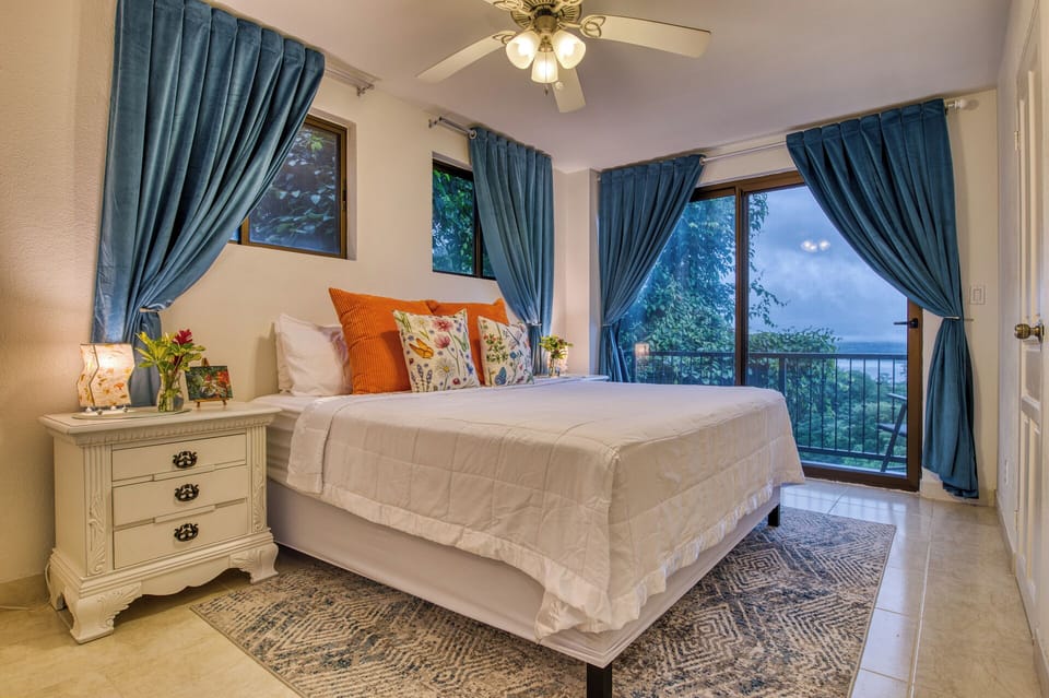 The primary suite enjoys beautiful lake views and a balcony to enjoy your morning coffee and watch the toucans flit from tree to tree.