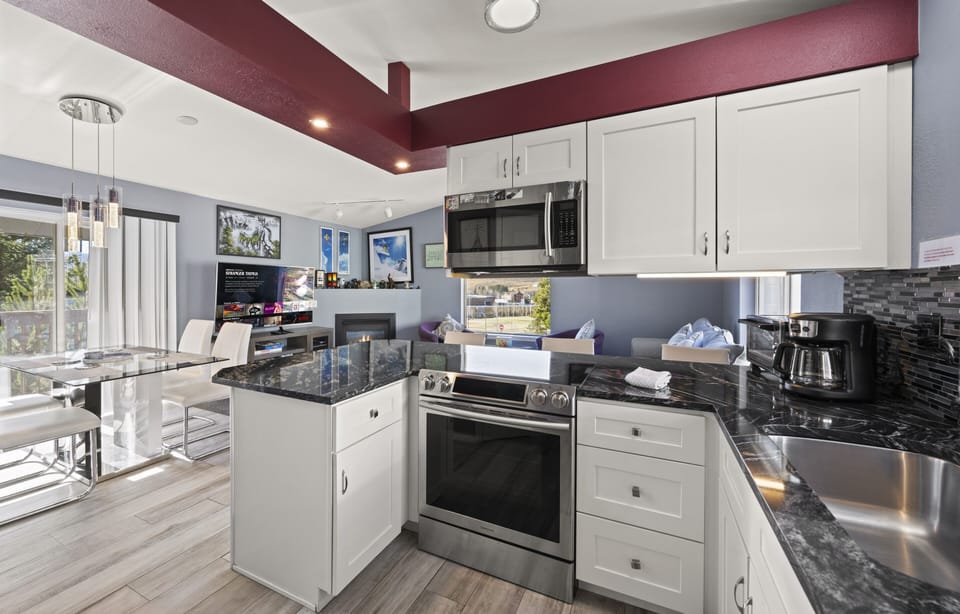 Modern kitchen with stove, island prep space, and bright natural lighting.