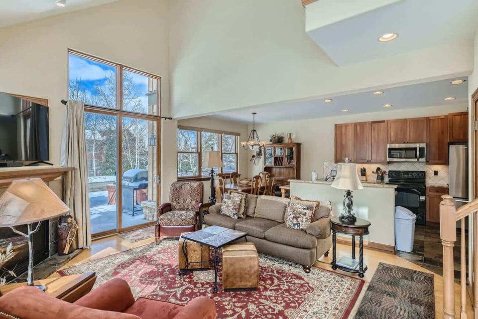 Living room with flat screen TV, gas fireplace, and patio access