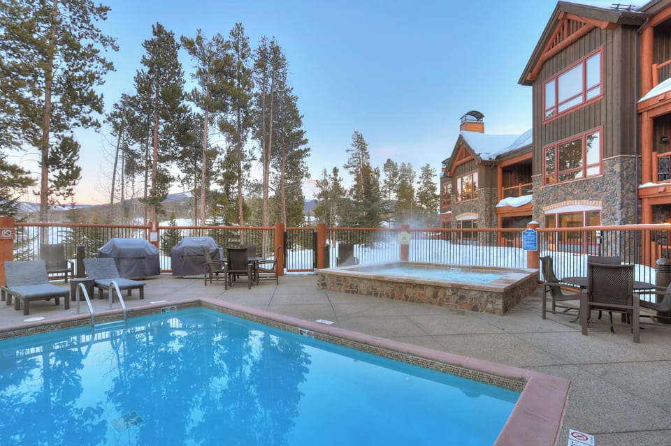 Outdoor pool surrounded by tall pines.