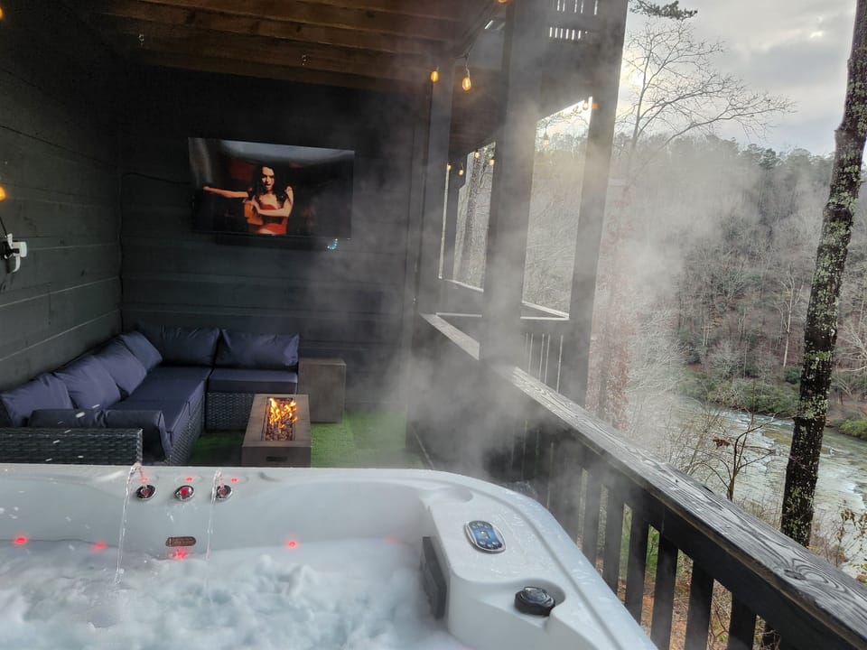 Soak in the hot tub with river views, fire feature, and mountain mist.