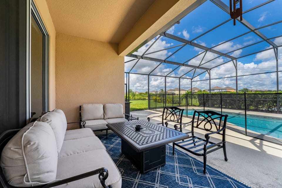 covered lanai with causal seating overlooking the pool