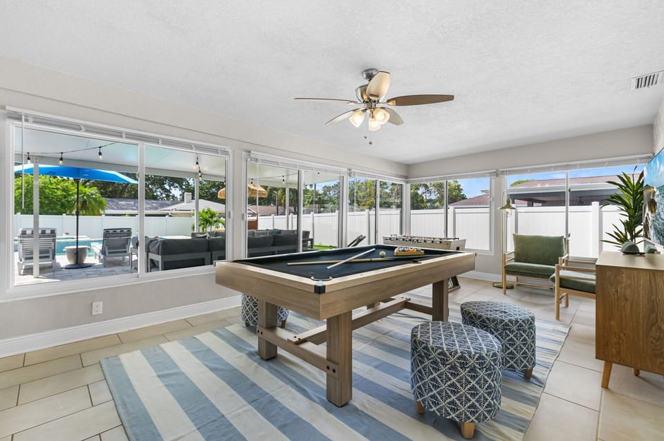 Let the light in while you play—our game room features a smart TV, pool table, foosball, and stunning expansive windows