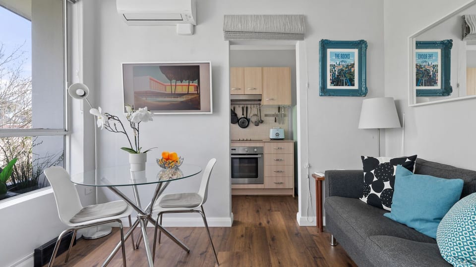 Relax in this inviting and well-lit living space, featuring a comfortable seating area, a bright dining nook, and seamless access to a functional kitchen