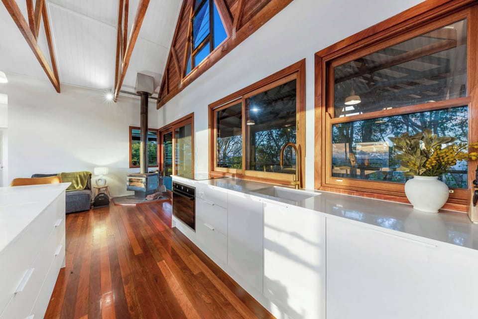 Cook and relax in this bright, spacious kitchen with beautiful wooden accents and scenic views through large windows.