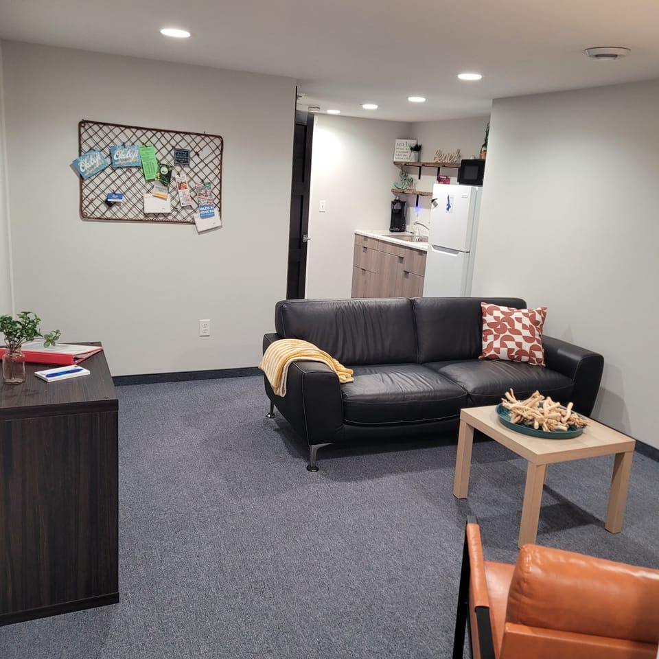 Living room area with smart tv, cable tv and wifi. A couch and 2 chairs.