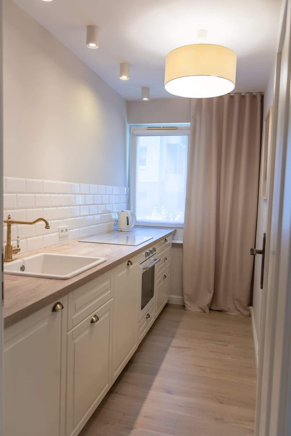 A compact kitchenette with wooden countertops and a modern backsplash, fully equipped for everyday cooking.
