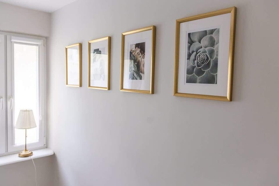 A hallway gallery with framed artwork and gentle lighting. The clean design adds visual interest without overwhelming the space.