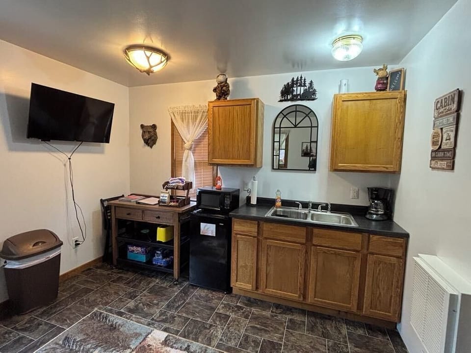 Woodsy Kitchen w/ mini fridge, microwave, coffee maker, toaster, dinnerware.