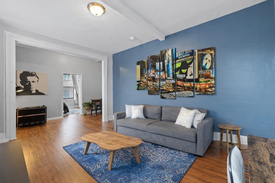 Bright lounge with blue accent wall, comfy sofa, hardwood floors & art