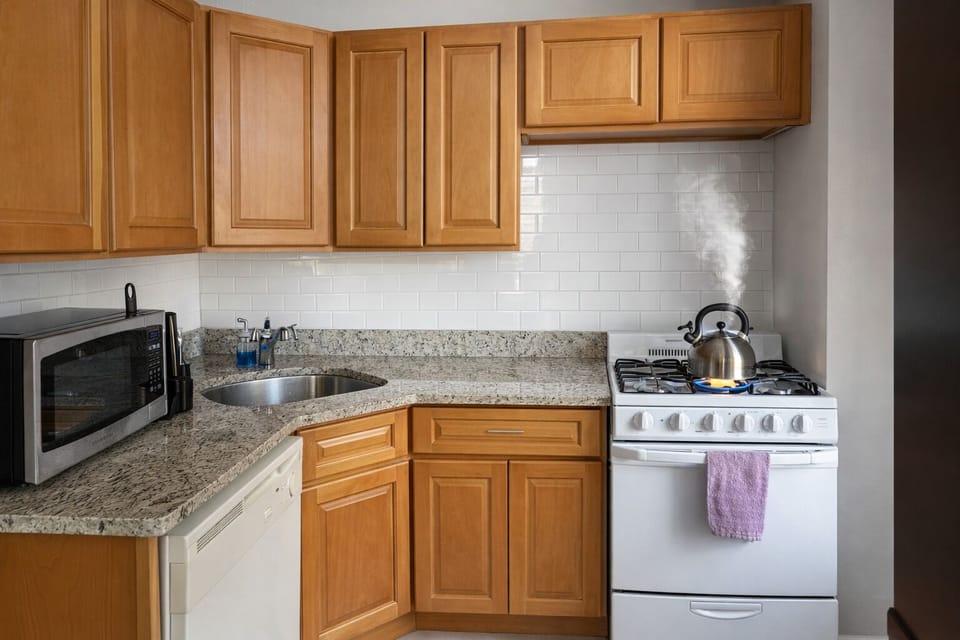 Cozy, fully equipped kitchen with gas range, dishwasher, and granite tops