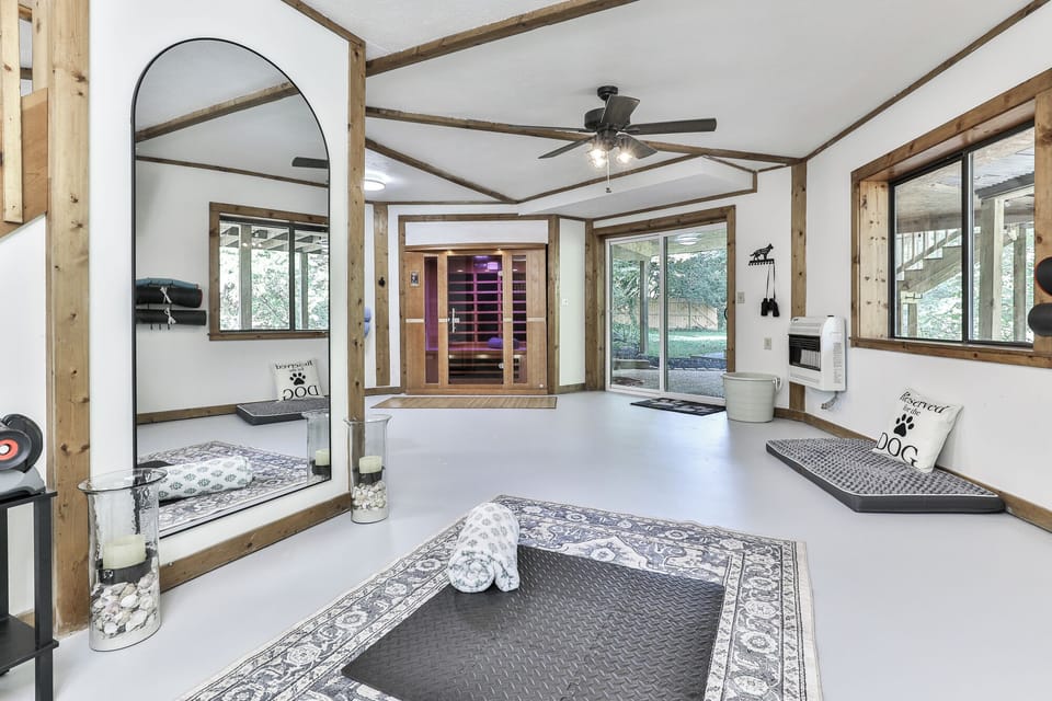 On the basement level, you’ll find a full bath with a walk-in shower, an infrared sauna, zero-gravity chairs, yoga mats, weights, an exercise bench, and a bike. Turn on the TV, cue up your favorite workout or music, make this your personal wellness oasis.
