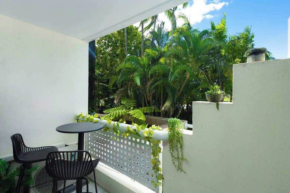 Step outside to the private balcony, an inviting spot for morning coffee or evening drinks surrounded by tropical greenery and fresh Cairns air.