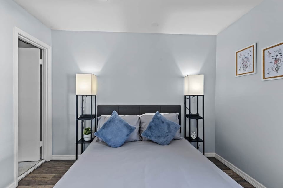 Queen size bed with two nightstands and outlet chargers within them.