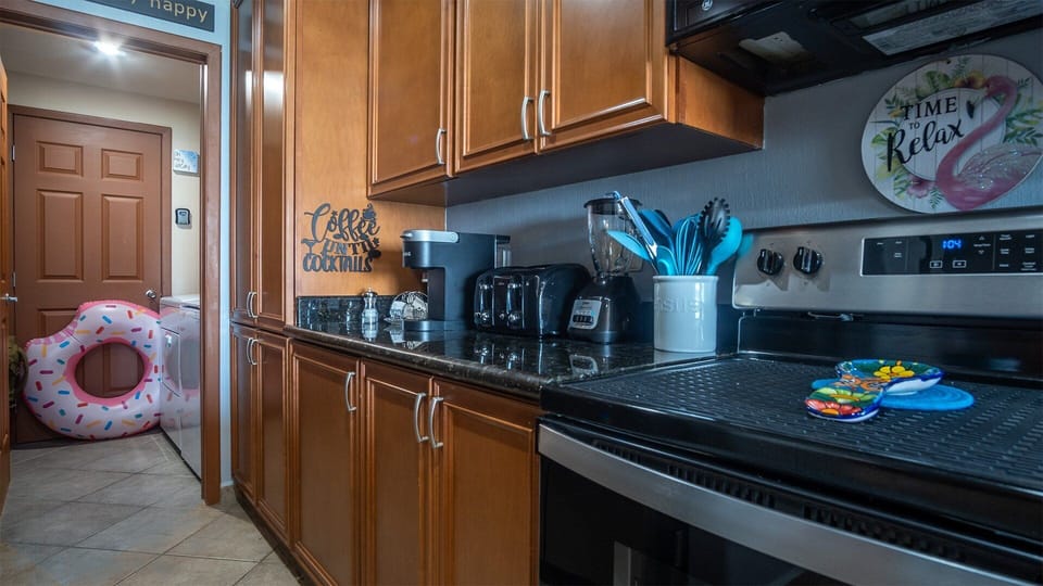 The kitchen with its appliances as it Leeds to the washer and dryer.