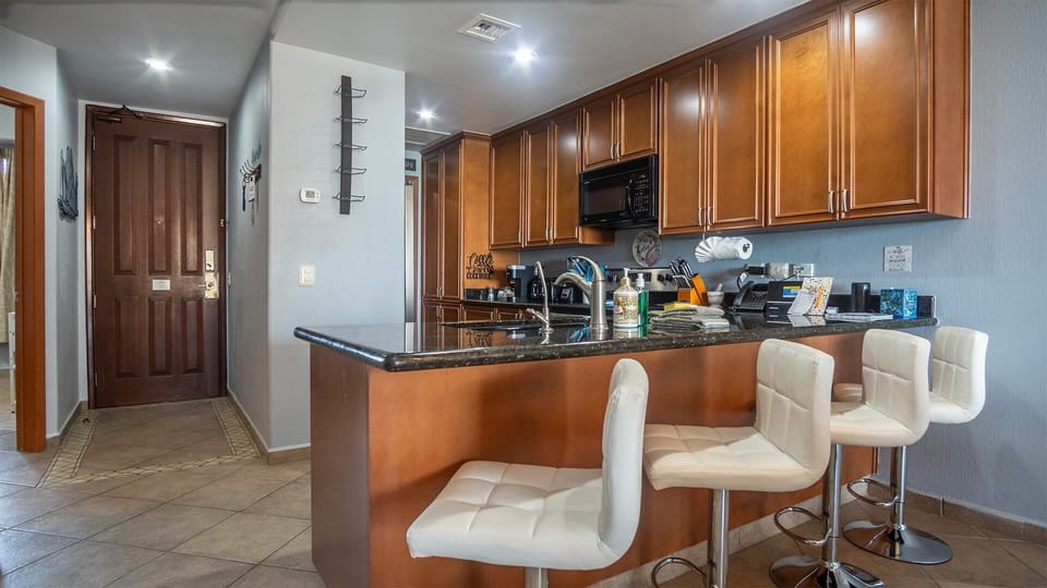 Raised upholstery stools are found at the kitchen counter.