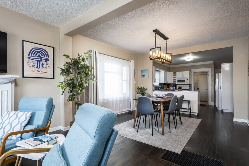 Open floorplan with living room flowing into dining area with seating for 6 at the table and 2 counter stools facing the large kitchen.