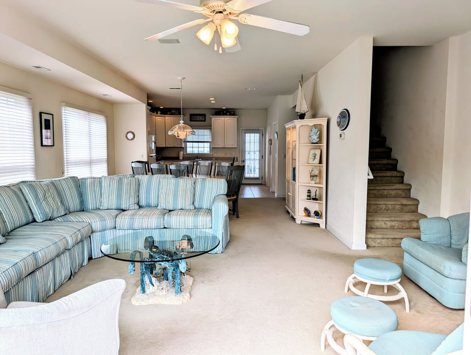 10 Dune Road (39544) - Living Area & Stairway - This view shows the main living level's transition to the upper floors. Nautical wall art and soft coastal tones tie the room together, offering a relaxed beach house vibe.