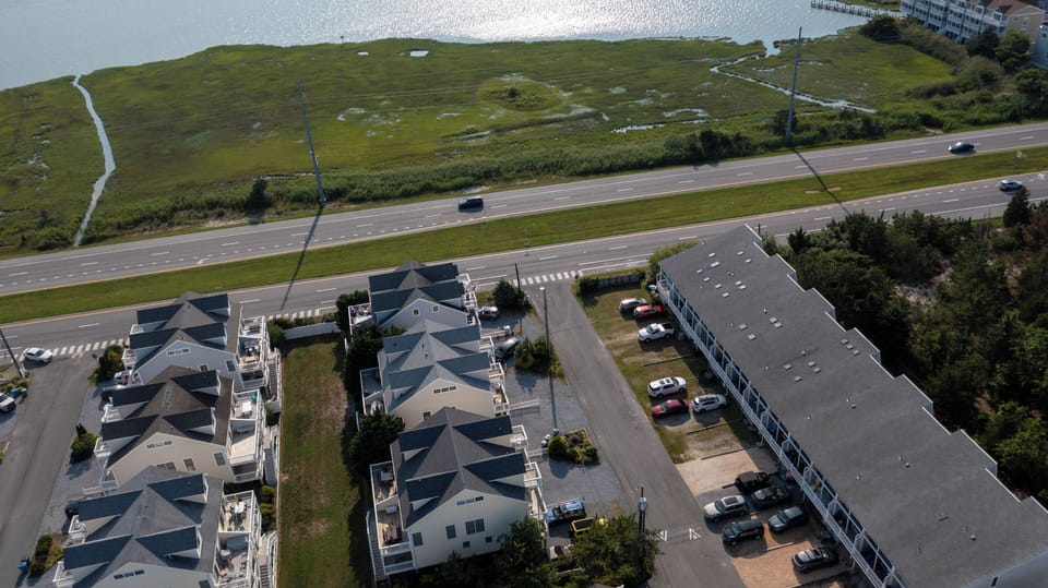10 Dune Road (39544) - Aerial View of Tower Shores - An aerial perspective showcasing the property's prime location between the Atlantic Ocean and the bay. This shot highlights the quiet residential feel of the community and its proximity to the water on both sides.