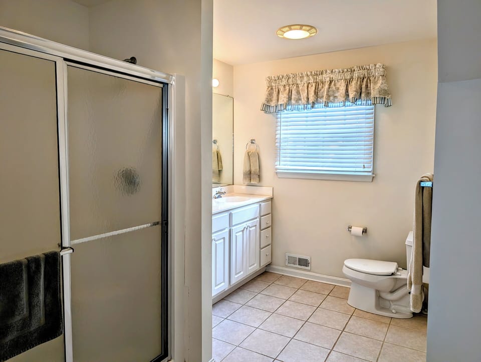 10 Dune Road (39544) - Primary Ensuite Bathroom - The primary ensuite bathroom features a large vanity and a glass-enclosed walk-in shower, offering convenience and privacy.