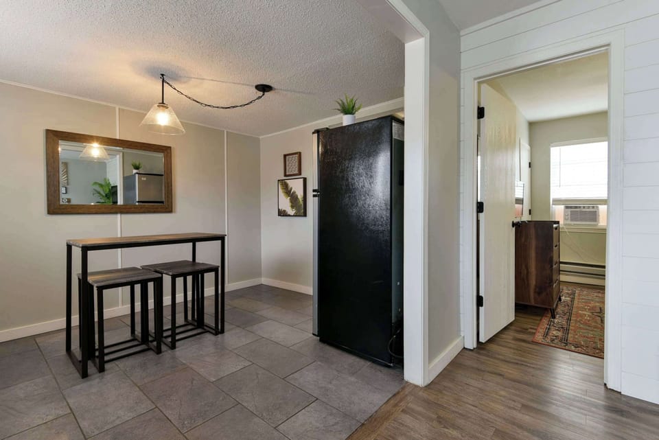 Living room with a view of the kitchen and entrance to the bedroom.