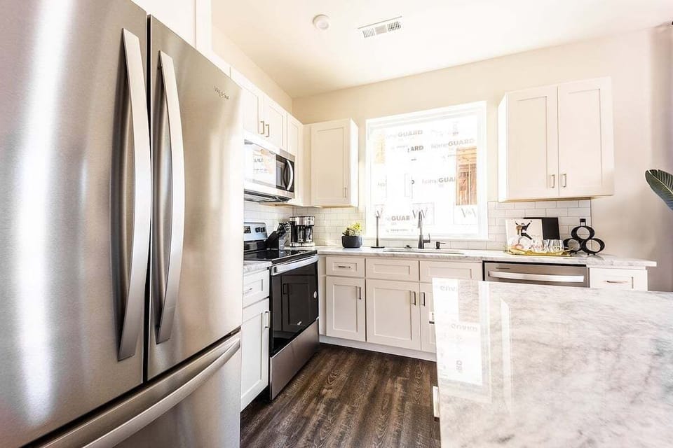 Full kitchen with stainless steel appliances and breakfast bar