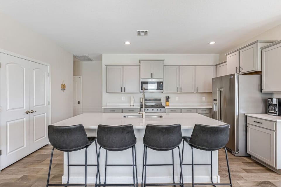 Sleek and modern kitchen with ample counter space, stainless steel appliances, and a spacious island with bar seating.