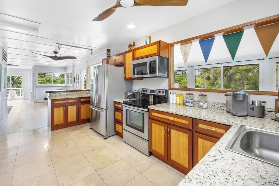 The open kitchen boasts stainless steel appliances and ample counter space.