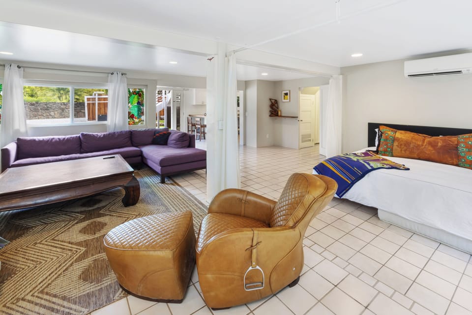 The spacious downstairs studio features a cozy seating area and a comfortable bed, making it a perfect private retreat.
