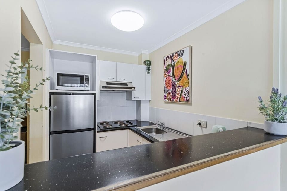 A fully equipped kitchenette with fridge, microwave, and stovetop — everything you need to self-cater with ease.