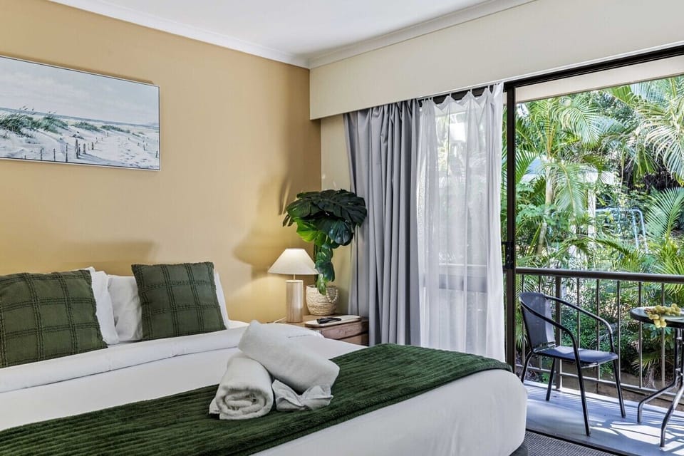 Crisp white linen, plush green throws, and your own private balcony overlooking the palms.