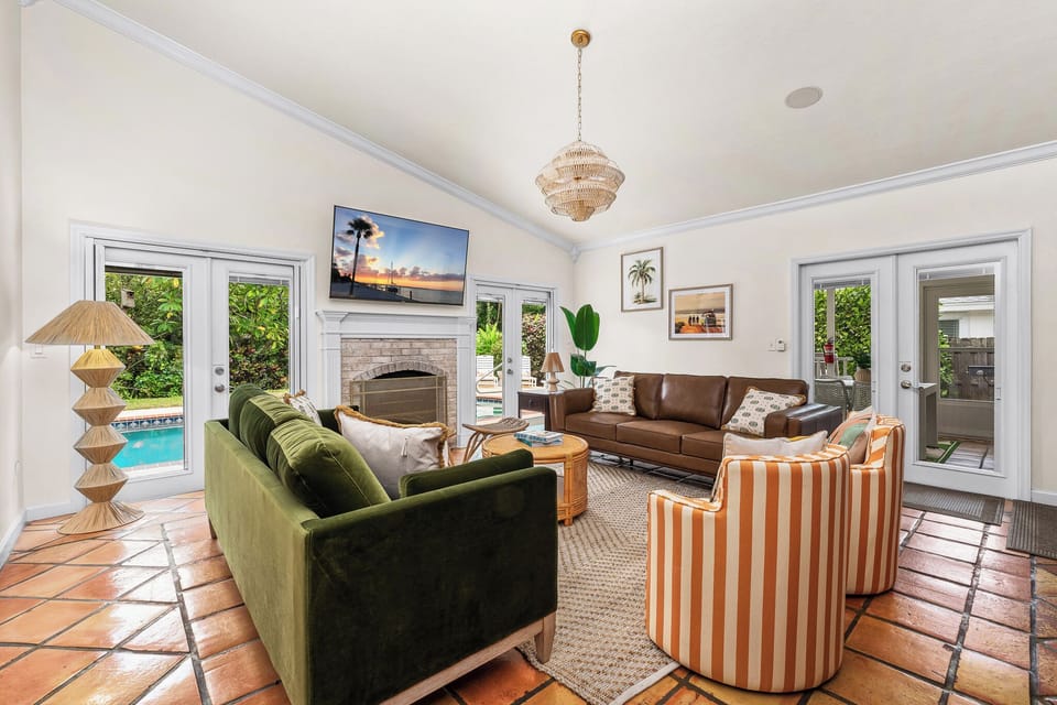 Relax in this colorful, cozy living room with pool views & fireplace ambiance 🔥