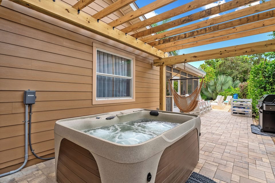 Step into pure relaxation—soak in the bubbling hot tub, surrounded by greenery and cozy seating, and let the serene atmosphere melt your stress away.