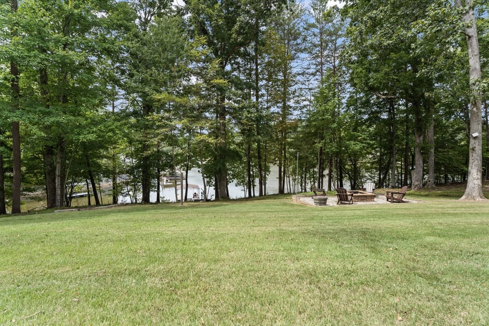 Large yard with firepit and gradual path to the lake.