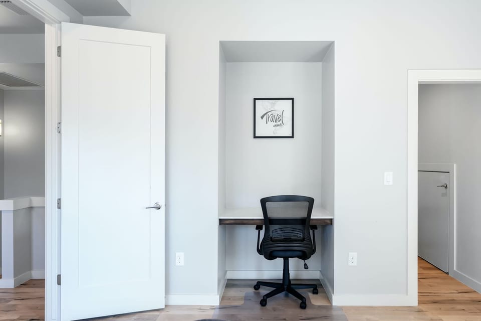 The 1st of 2 upper-level bedrooms, featuring a queen bed, desk, & Smart TV