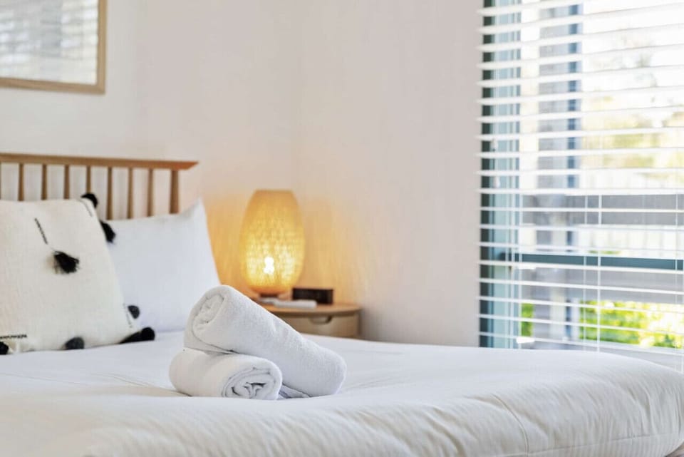 🛏️ Comfortable bed with fresh linens and towels provided for a relaxing stay