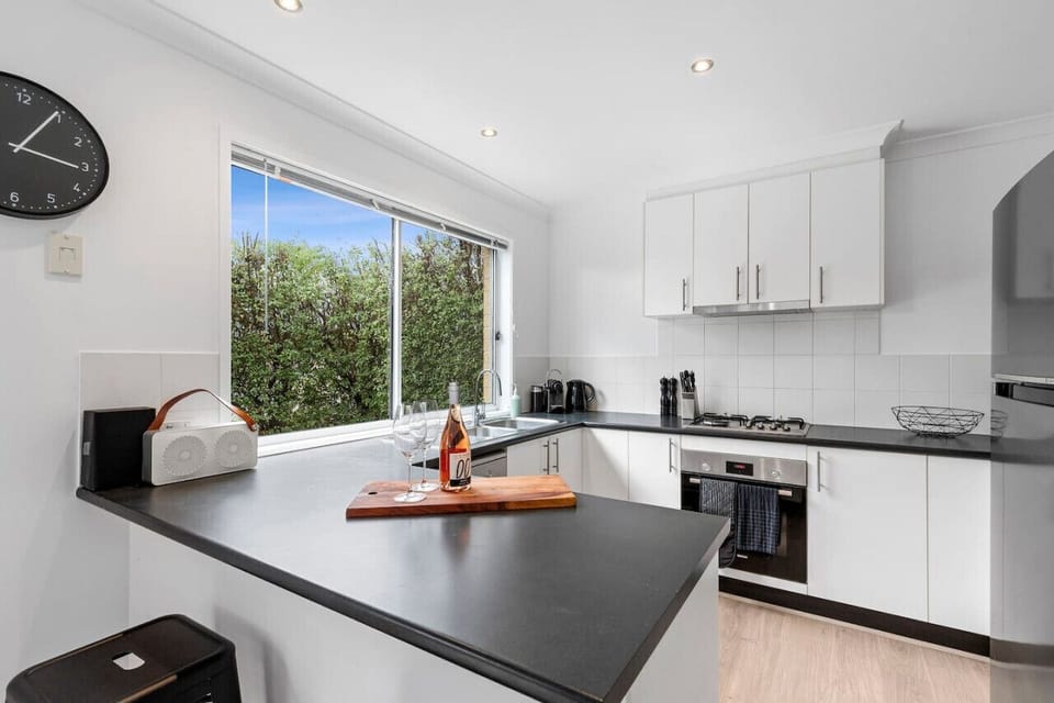 🍳 Fully equipped kitchen with modern appliances and ample bench space.