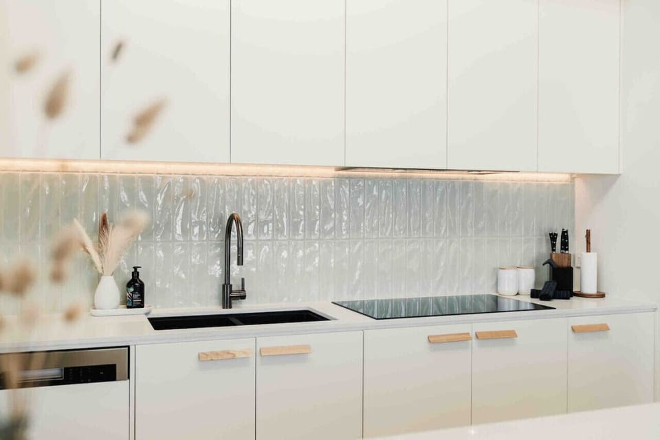 Bright modern kitchen with sleek cabinetry, warm lighting, and clean finishes