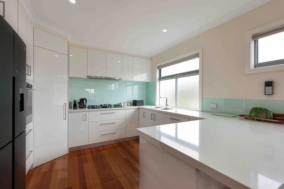 Fully equipped kitchen with island, sleek cabinetry, and natural light