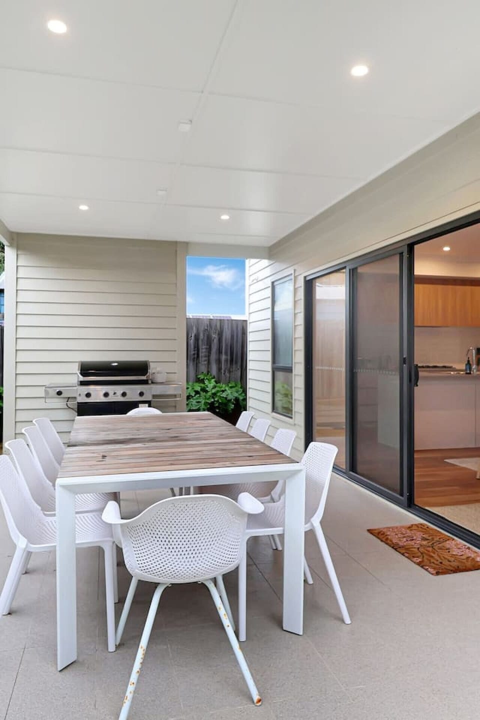 Covered outdoor dining area with BBQ and easy indoor access