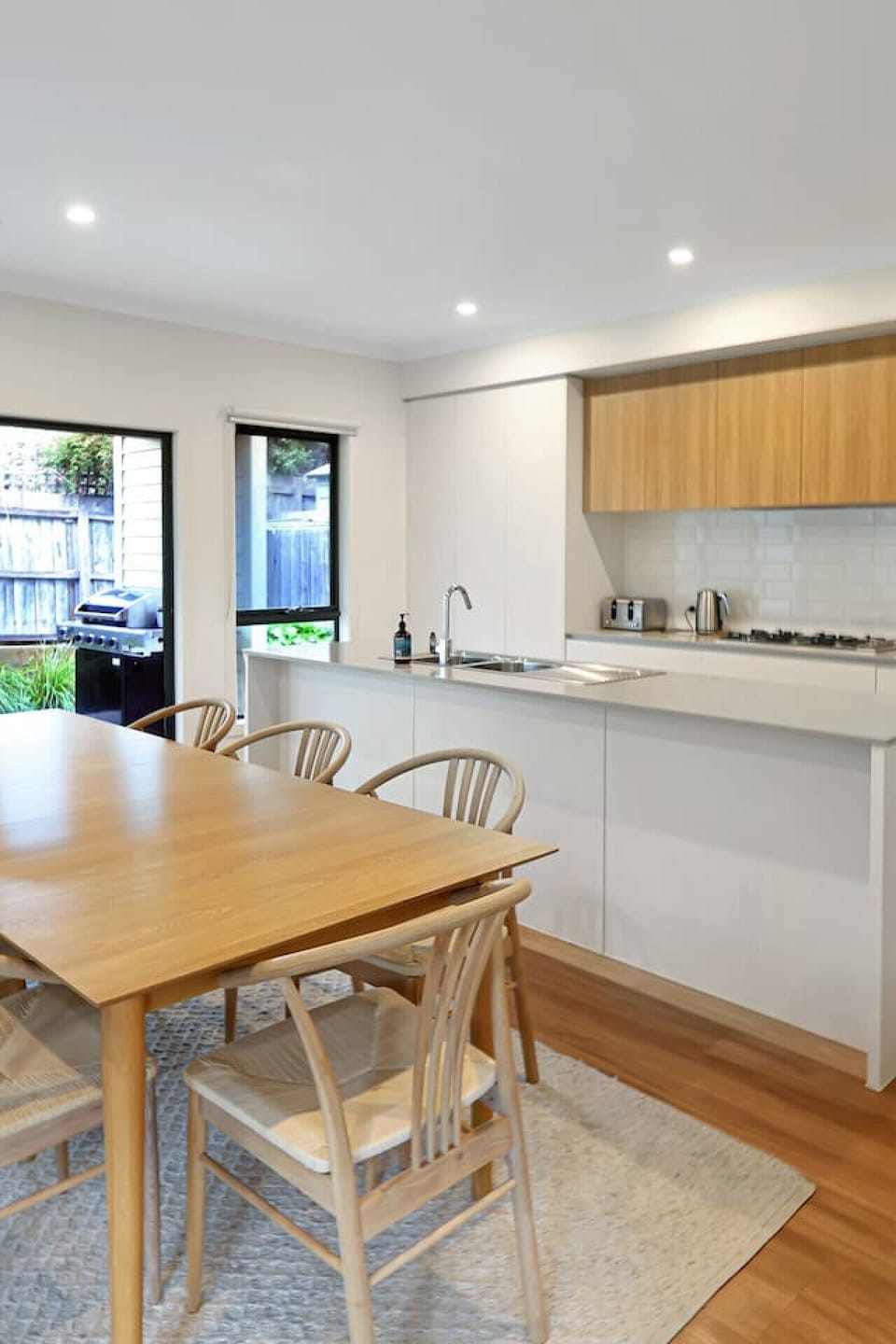 Open-plan kitchen and dining space leading directly to the outdoor BBQ area