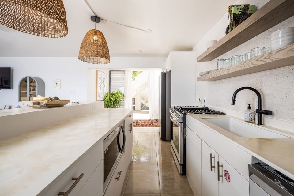 Sleek countertops and open wooden shelves add a stylish coastal touch.