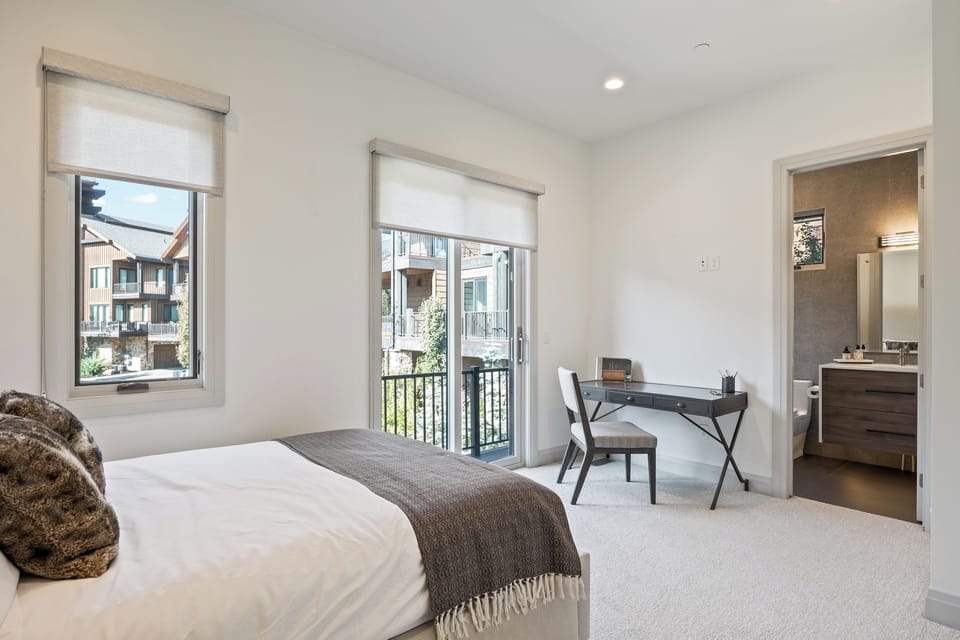 Inviting fourth bedroom with a queen bed, workspace, and access to an ensuite bathroom. Perfect for guests who appreciate both comfort and functionality.