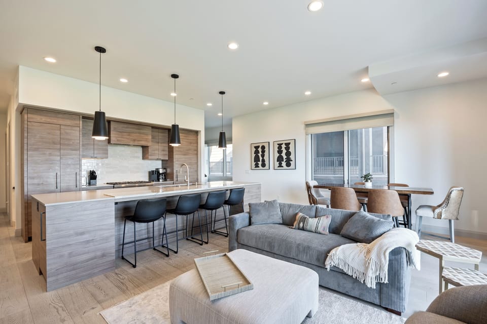 Modern open-concept kitchen and living space featuring a long island with bar seating, updated appliances, and a seamless flow into the living area—perfect for entertaining and shared meals.