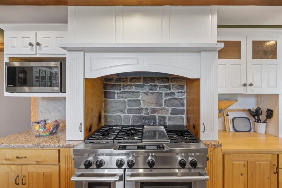 You're going to love cooking on this stove, with a gorgeous stone backsplash to compliment the space so well!