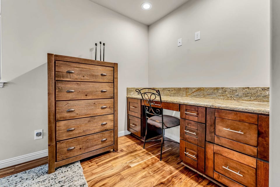 Bedroom 1: King bed, built-in workspace, dresser, en-suite bath, upper floor