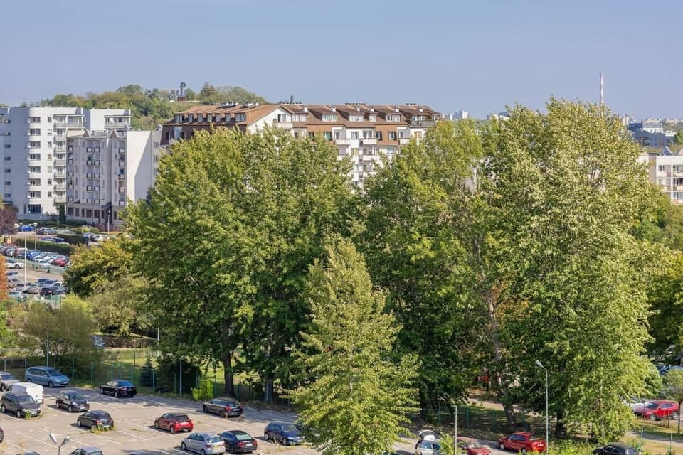 Another view of the apartment’s exterior from above, showing the building, trees, and open space. A quiet urban setting.