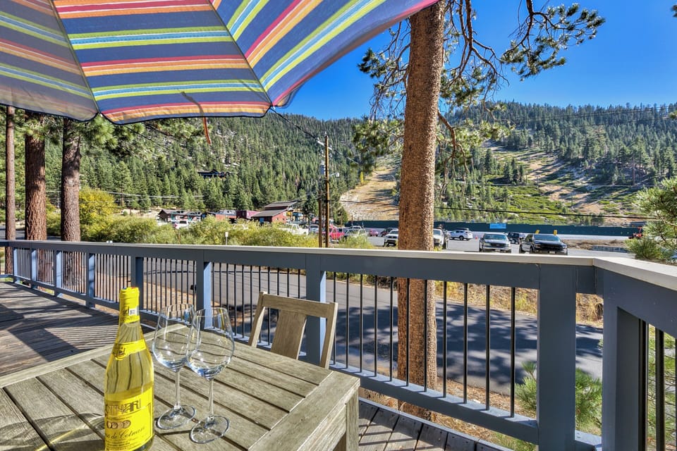 Enjoy your morning coffee on this charming deck with stunning mountain views and colorful umbrella shade.