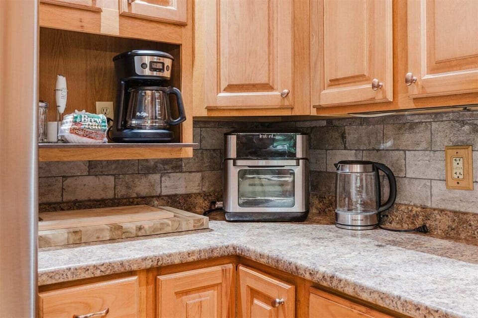 Kitchen counter setup with coffee maker and toaster oven, offering all the essentials for morning coffee and quick meals.