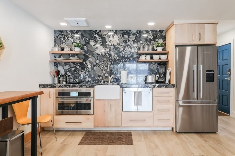 Left of sink is induction stovetop and combination convection/microwave/roasting oven. Right of sink is the drawer dishwasher.
